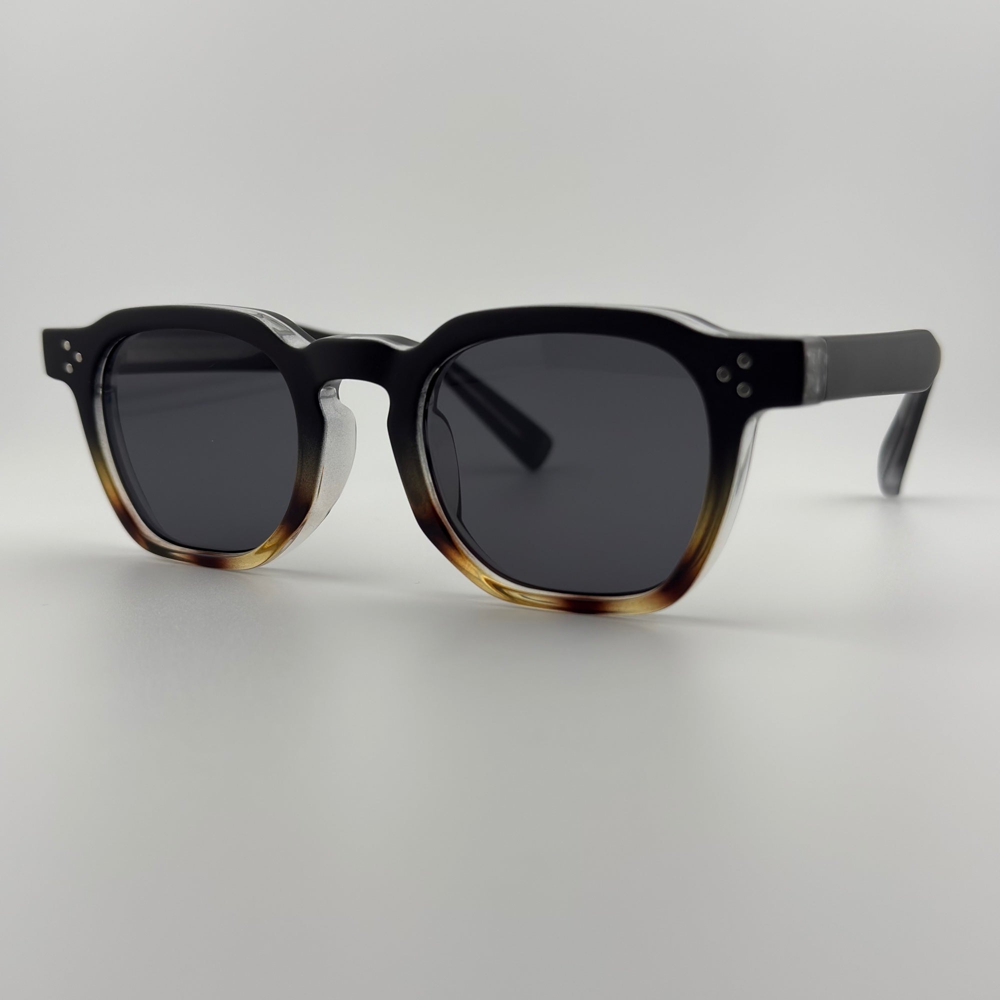 Velra Alton Stone Shade – lunettes de soleil, vue angle 3/4 : monture bicolore avec face noire et base écaille, branches épaisses et verres fumés pour un style affirmé.