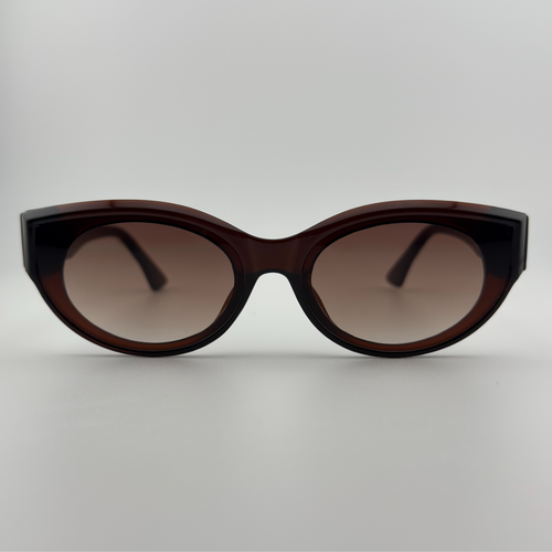 Velra Elyria – lunettes de soleil, vue de face : monture marron translucide et verres bruns pour une élégance sobre et affirmée.
