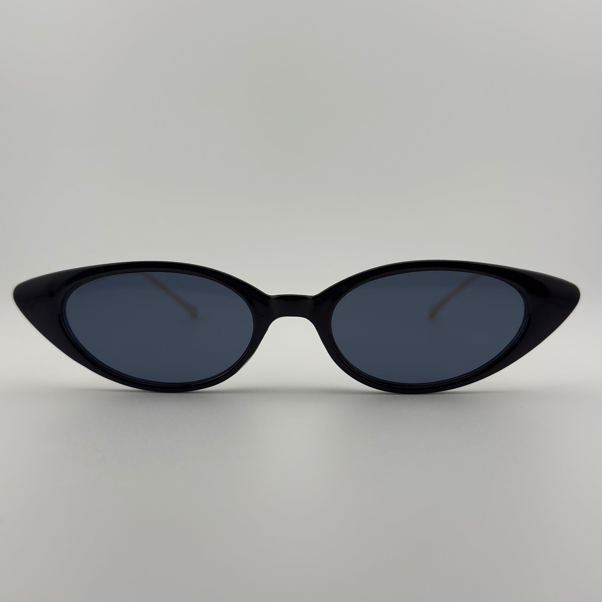 Velra Naika lunettes de soleil noir, vue de face – design œil-de-chat pointu et branches dorées pour une allure affirmée et luxueuse.
